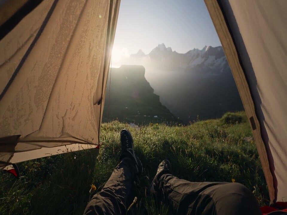 View out of a tent onto mountains at sunrise